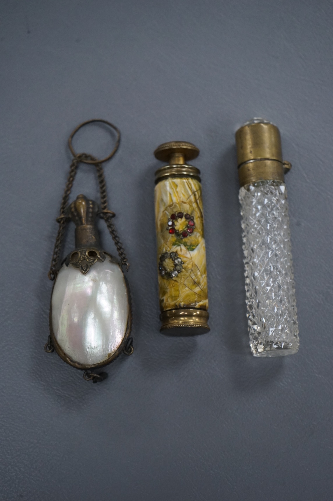 A pump-action scent flask or atomiser and two others, longest 8.5cm